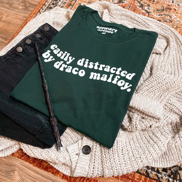 “Easily distracted by: D.M." Tee